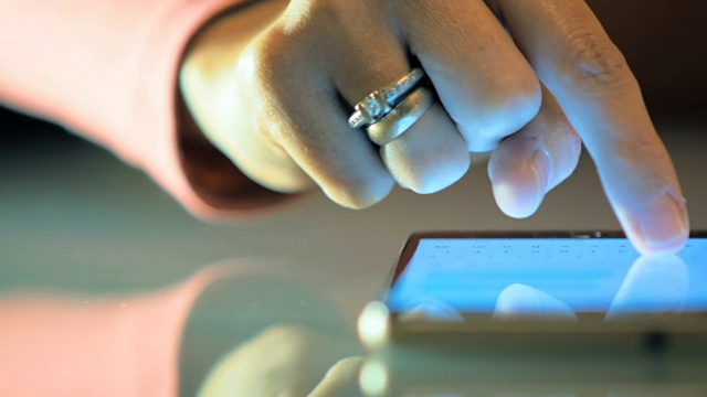 一个女性的手在智能手机上写信息给她的朋友的特写。视频素材