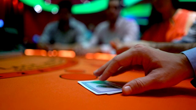 一个面目全非的人在牌桌上赌钱，举起他的牌看他们视频下载