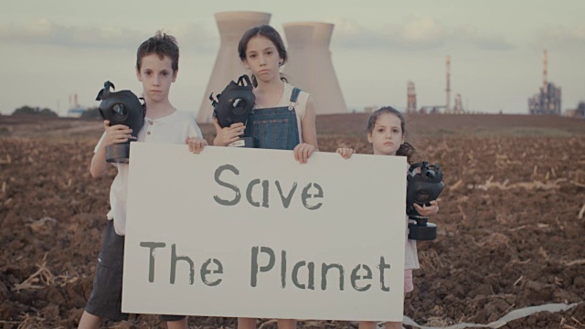 保存植物。在炼油厂附近，小孩子们举着带防毒面具的牌子视频素材