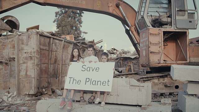 拯救地球。小孩子拿着牌子站在垃圾场里视频素材
