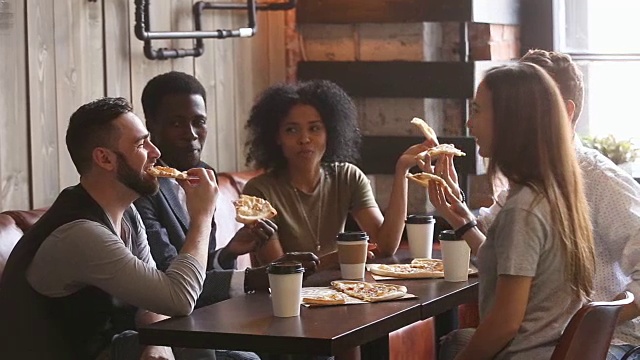 不同的朋友一起吃披萨，在披萨餐厅吃午餐视频素材