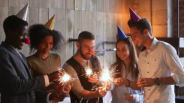 快乐的多民族朋友点燃火花在派对帽子一起庆祝视频下载