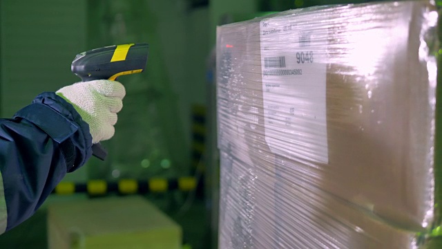 条形码扫描仪。工人在仓库里用条形码扫描仪检查货物。4 k。视频素材