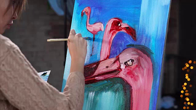 一位年轻的艺术家用油画颜料画了一幅火烈鸟的画视频下载
