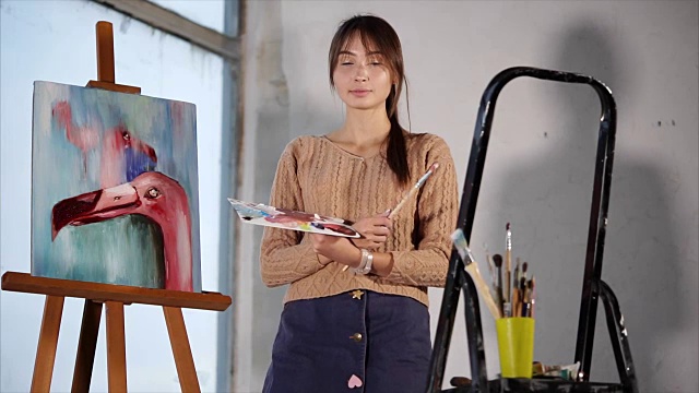 一位专业艺术家站在她完成的粉红色火烈鸟旁边视频下载