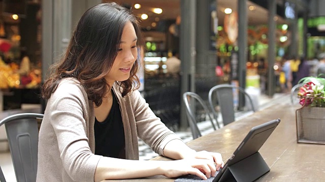 亚洲女性在外面使用数字平板电脑视频下载