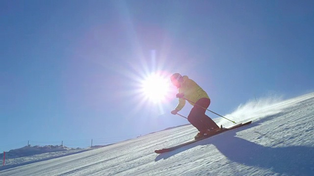 跟踪慢动作滑雪在太阳的耀斑在一个新鲜的早晨整理雪道视频素材