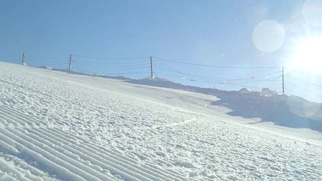 慢动作跟踪:完美整理的雪与滑雪者雕刻下斜坡视频素材