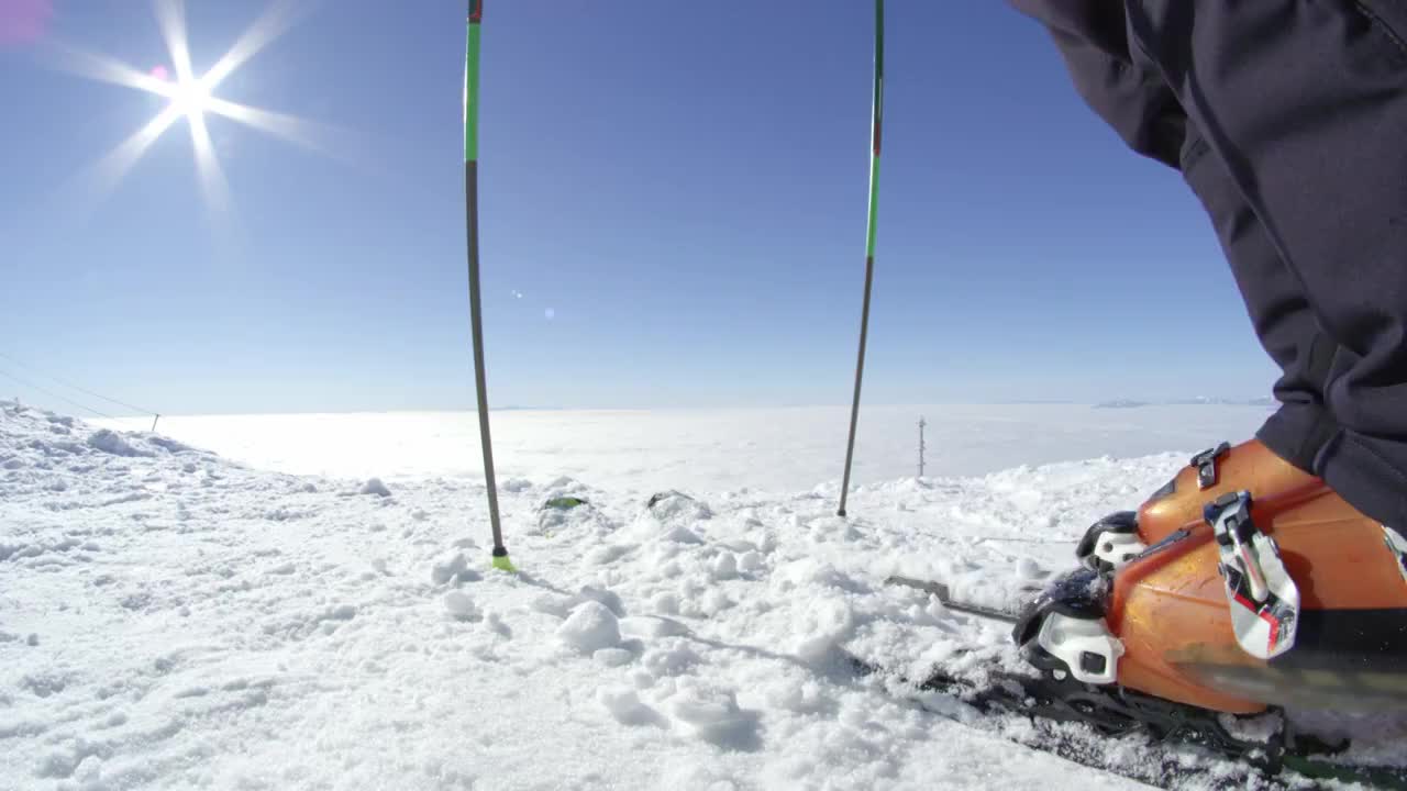 慢镜头特写:滑雪者从山顶的滑雪板上取出新雪视频素材