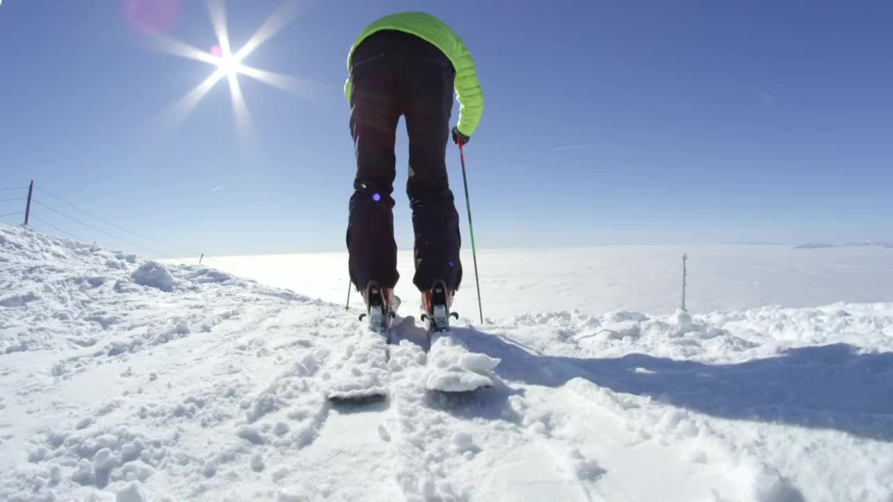 在一个阳光明媚的冬日里，慢动作滑雪者在山顶上开始滑雪视频素材