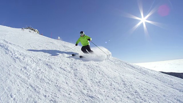慢镜头:滑雪胜地，一名年轻的滑雪者在镜头中向雪地喷洒雪时停下来微笑视频素材