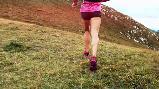 SLO MO女跑步者在高山草地上跑步视频素材
