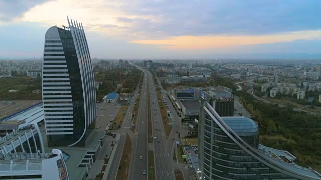 美丽的无人机在城市高速公路上的公司大楼之间飞行视频下载