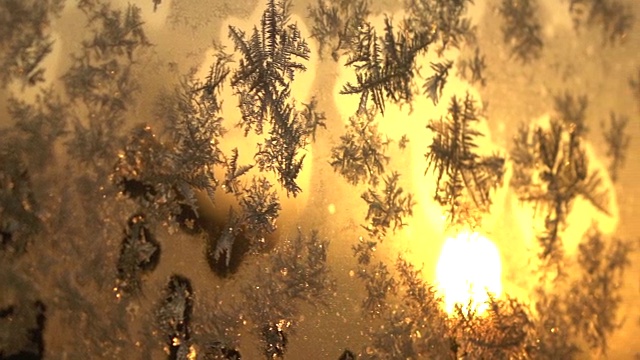 近距离的自由度:美丽的冰冻冰图案在寒冷的窗户在冬季日落视频下载
