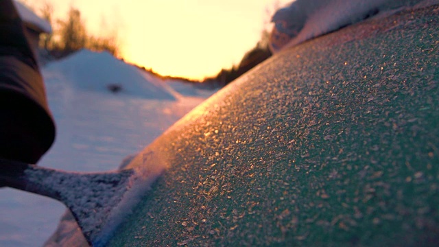 慢镜头特写:冬日日出时，从后窗刮去晨霜视频素材