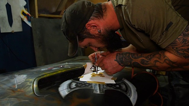 大师在汽车的引擎盖上创作航空绘画视频素材