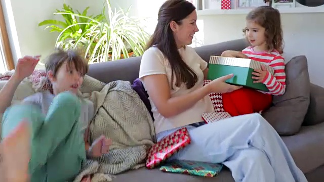 孩子们在沙发上打开圣诞礼物视频素材