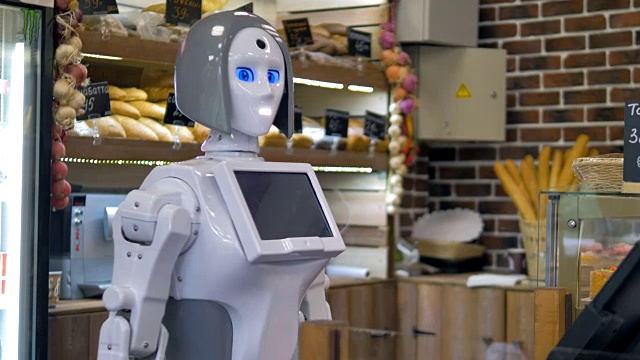 一个白色机器人在面包店柜台工作。视频素材
