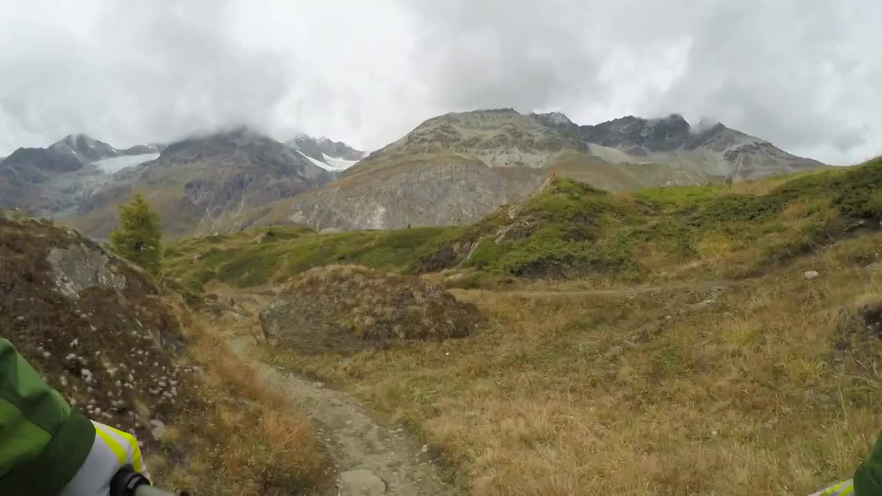山地自行车手从远处标志性的山的斜坡上下来视频下载