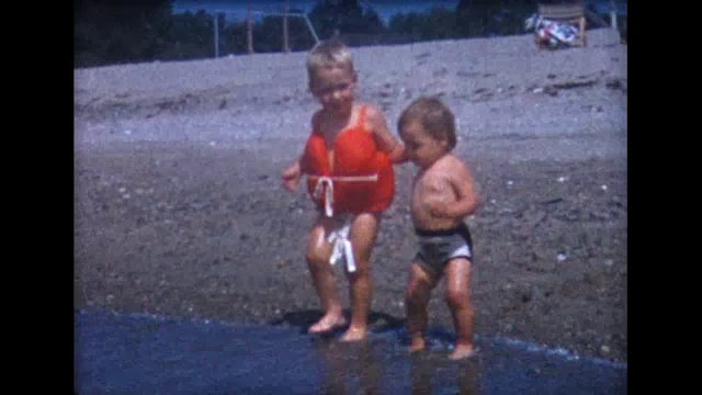 1958年哥哥牵着姐姐的手下水视频素材