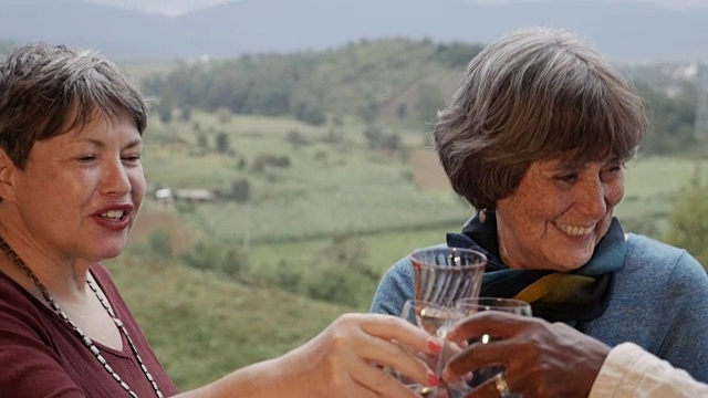 三位活跃的老年女性在外面举杯，欣赏迷人的山景视频素材