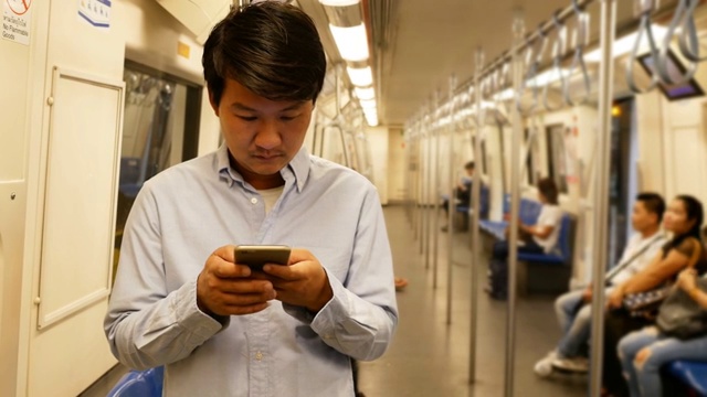 亚洲男子在火车上使用智能手机视频素材