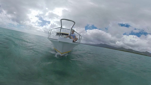 一名男子喜欢在毛里求斯附近的海洋中乘坐游艇水上旅行视频素材