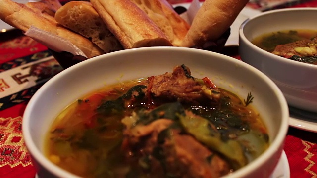 美味的阿塞拜疆民族羊肉汤在餐厅。以面包玉米饼为背景的白色盘子里的肉汤视频素材