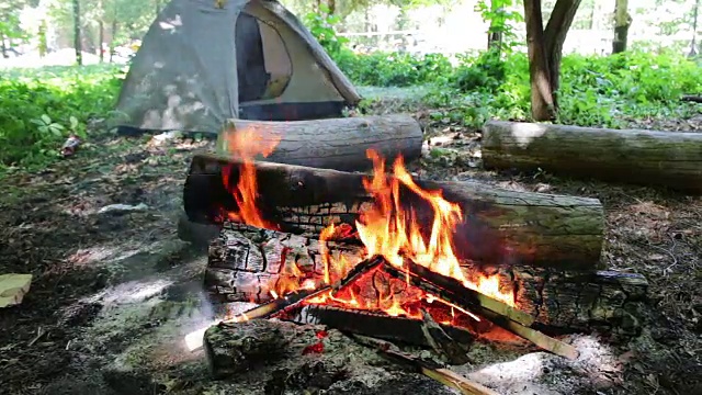 在旅游帐篷的背景中，燃烧着的火和木头视频素材