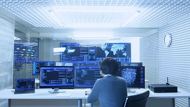 在系统控制监控室操作员使用多个显示器显示图形，物流，神经网络。数据中心是光明和充满先进技术。视频素材