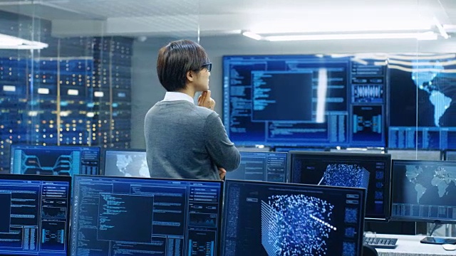 在系统控制室，技术操作员站在和监控各种活动显示在多个图形显示器上。人工智能、大数据挖掘、神经网络、监控项目。视频素材