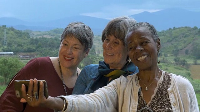 三名活泼的60多岁老年女性度假时用智能手机自拍视频素材