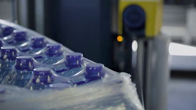 工厂用传送带将塑料瓶加水包装的过程视频下载