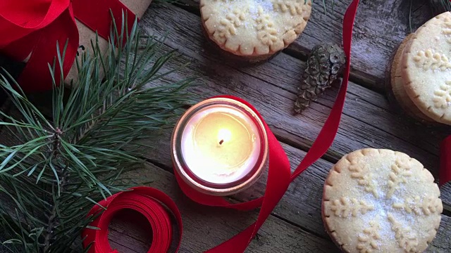 特写燃烧的白色蜡烛和圣诞肉馅饼在质朴的木头桌子上。概念的冬季假期和圣诞烘焙。前视图。视频下载