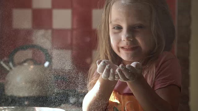 小女孩在厨房里吹面粉视频素材
