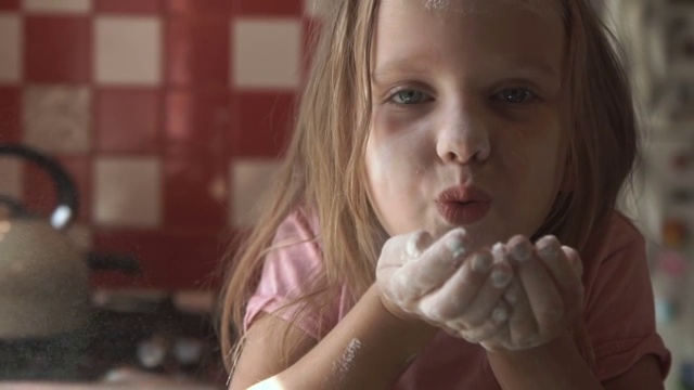 小女孩在厨房里吹面粉视频素材