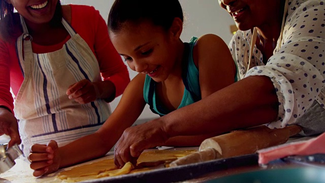 多代同堂的幸福家庭在厨房里准备饼干视频素材