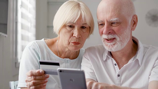 老夫妇在家。在智能手机上用信用卡购物。退休后活跃的现代生活视频素材