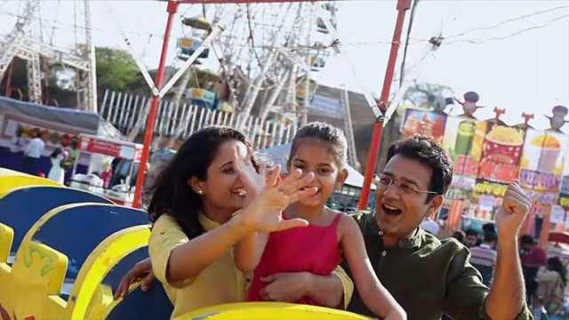 一家人在印度哈里亚纳邦的苏拉吉昆德集市上享受游乐设施视频素材