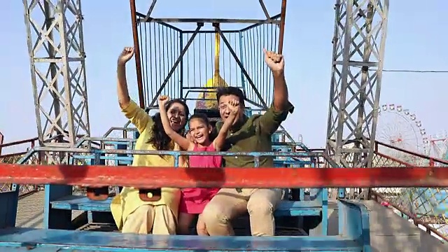 一家人在印度哈里亚纳邦的苏拉吉昆德集市上享受游乐设施视频下载