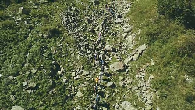 无人机观看徒步行走在山谷。山俯瞰视频下载