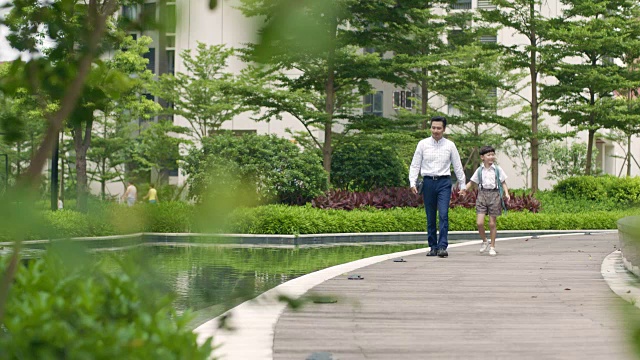 亚洲父亲护送儿子去学校在花园慢镜头视频素材