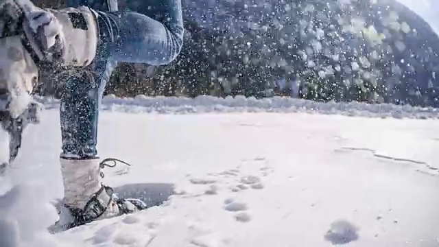 在白雪覆盖的山坡上穿雪鞋的女人视频素材
