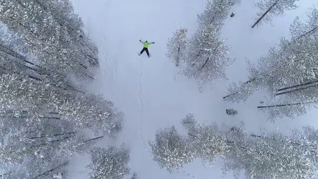 在冬天，一个不知名的人在新雪中制作雪角视频素材