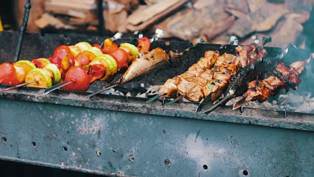 串在烤肉串上的鲜美肉在火盆上炸。用猪肉和蔬菜做成的烤肉串视频素材