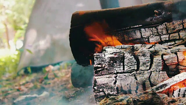 在旅游帐篷的背景中，燃烧着的火和木头视频素材