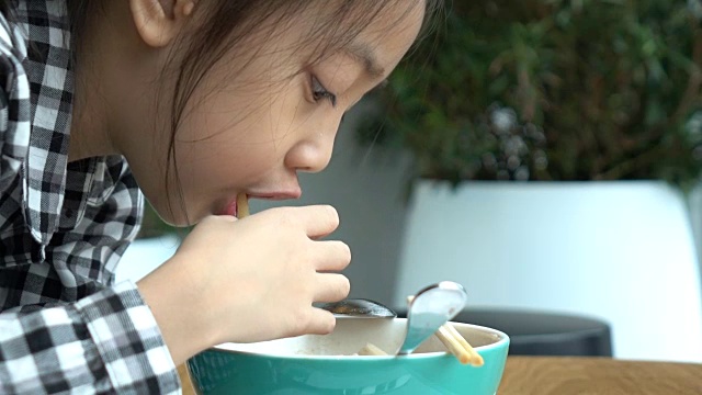 亚洲小女孩吃日本乌冬面，慢动作拍摄视频素材