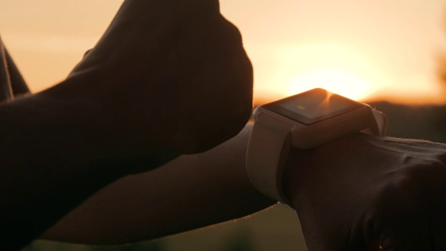 日落时分，一名女子在森林中使用智能手表视频素材