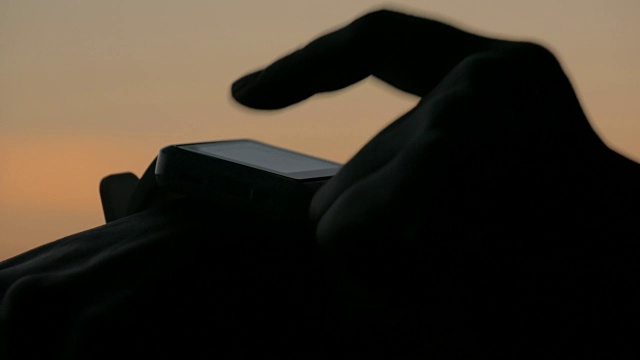 日落后在森林里使用智能手表的女人视频素材