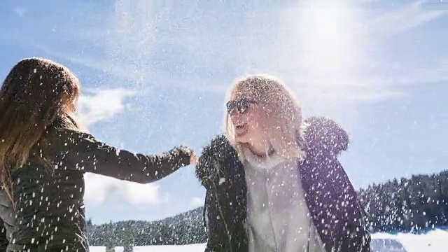 在阳光明媚的冬日里，年轻的女性在冬日的风景中击掌视频素材